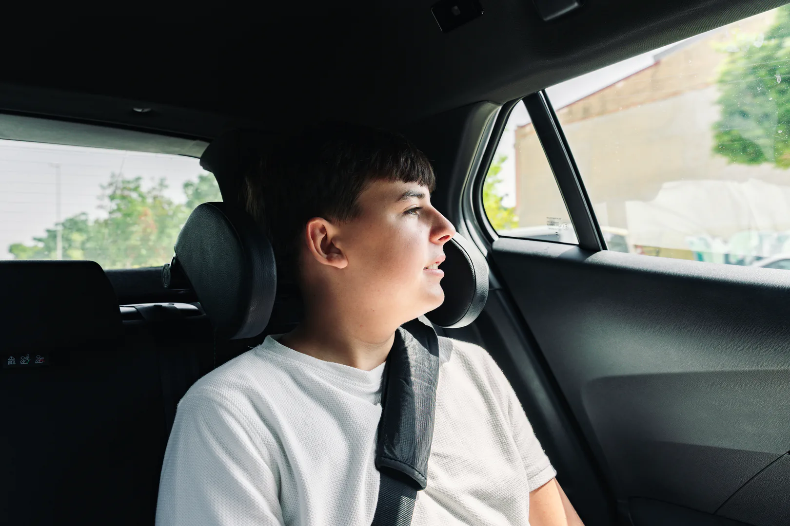 Adolescente utilizando un reposacabezas en el coche